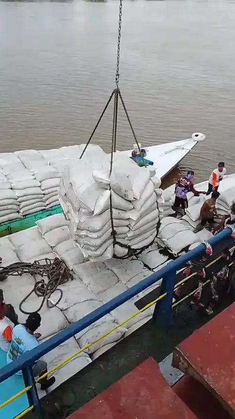 Muatan kernel karungan diangkat dengan sling crane dari palka kapal